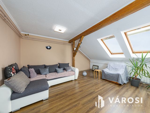 Látszó fagerendás tetőtéri lakás csendes utcában